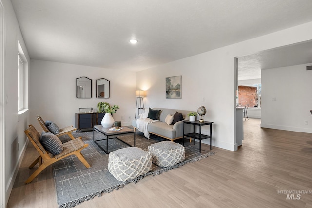 living area featuring visible vents, baseboards, and wood finished floors