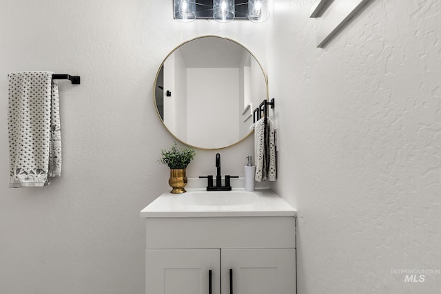 bathroom featuring vanity and a textured wall