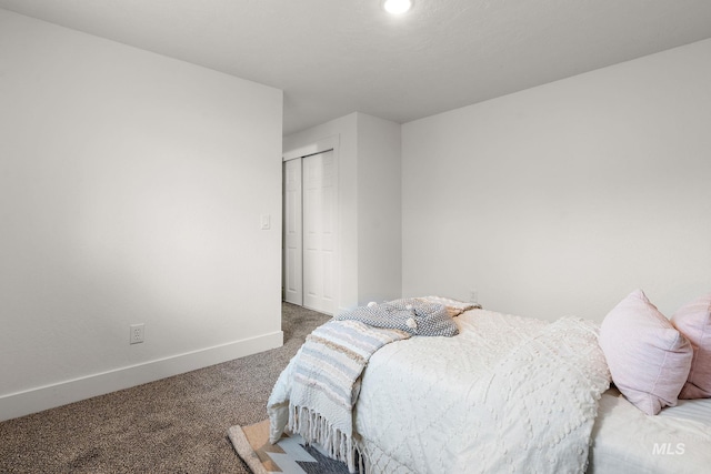 bedroom with baseboards, carpet floors, and a closet