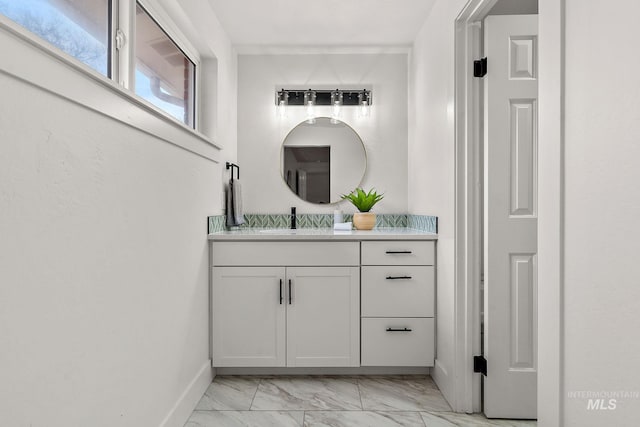 bathroom with vanity, baseboards, and marble finish floor