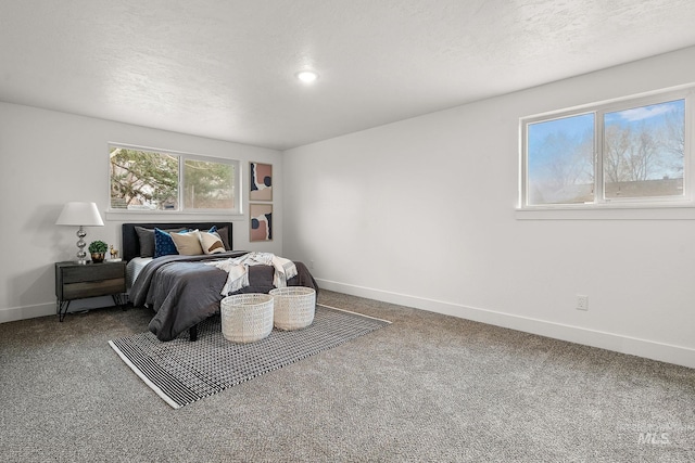 bedroom featuring carpet flooring, a textured ceiling, and baseboards