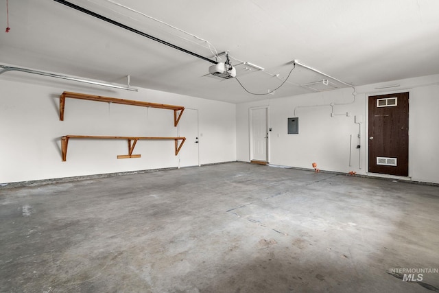 garage featuring electric panel, a garage door opener, and visible vents