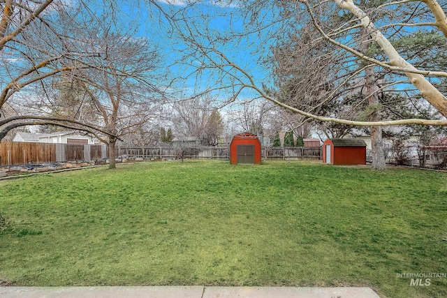 view of yard featuring an outbuilding, a storage shed, and a fenced backyard