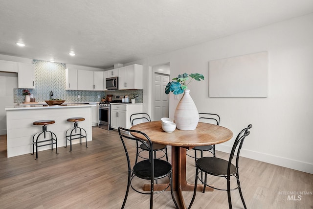 dining area with light wood-style flooring and baseboards