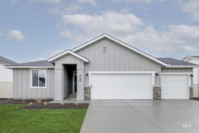 view of front of house featuring board and batten siding, concrete driveway, a garage, and a shingled roof