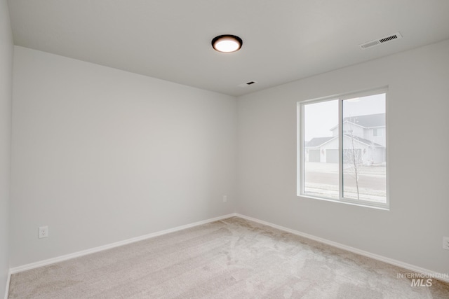 empty room with visible vents, baseboards, and carpet floors