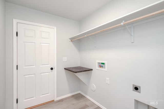 clothes washing area featuring baseboards, laundry area, hookup for a washing machine, light wood-style floors, and electric dryer hookup