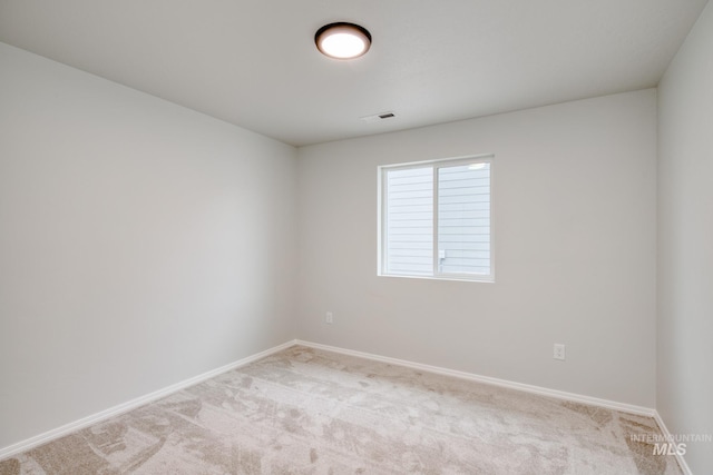 unfurnished room featuring baseboards, visible vents, and light carpet