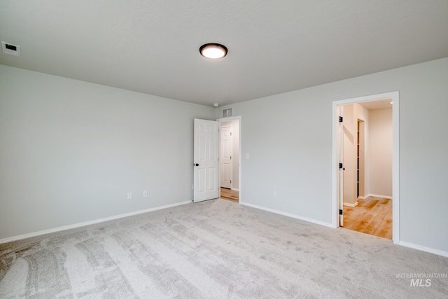 unfurnished bedroom featuring visible vents, carpet floors, and baseboards