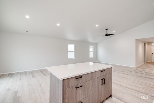 kitchen with light brown cabinetry, open floor plan, light countertops, light wood-style floors, and modern cabinets