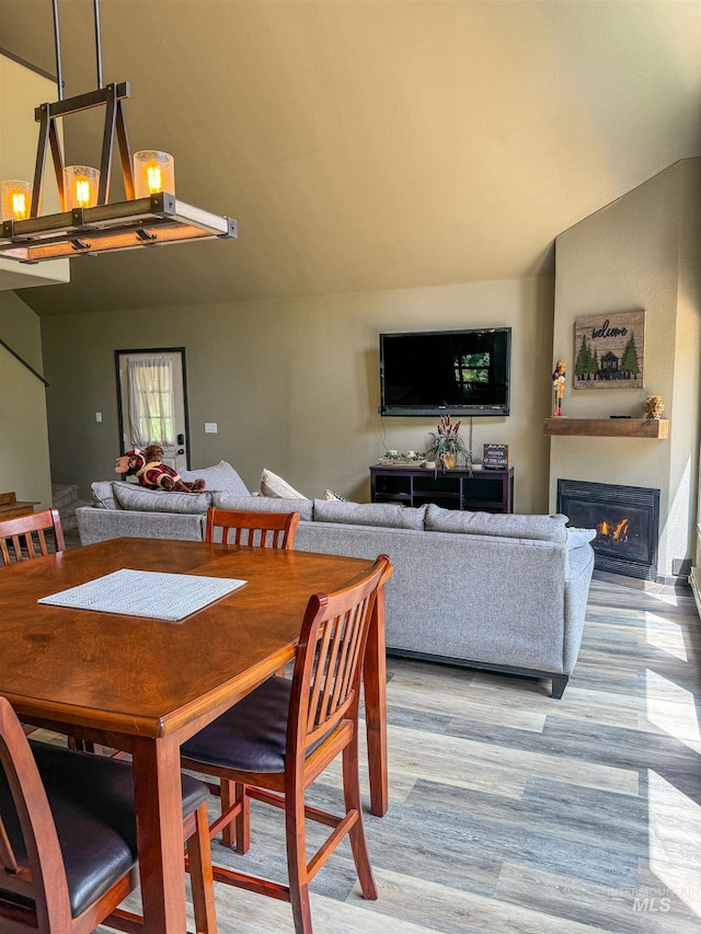 dining space featuring light hardwood / wood-style floors and lofted ceiling