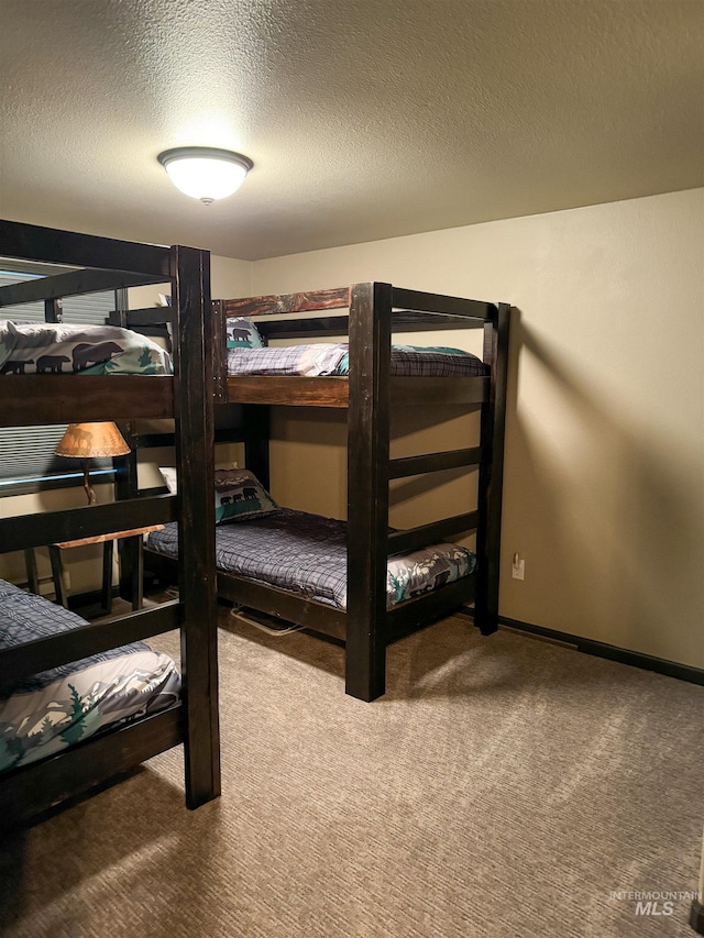 bedroom featuring carpet floors, a textured ceiling, and built in desk