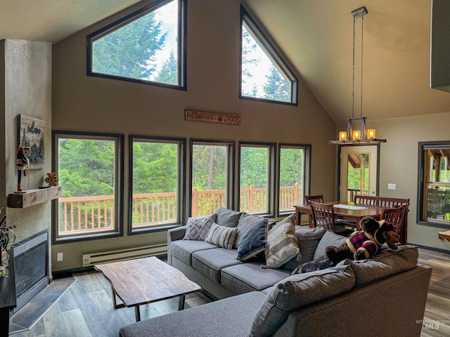 living room with a baseboard radiator, hardwood / wood-style floors, a healthy amount of sunlight, and high vaulted ceiling