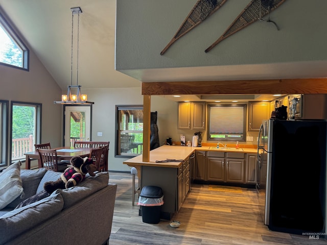 living room with high vaulted ceiling, sink, a chandelier, and light hardwood / wood-style floors