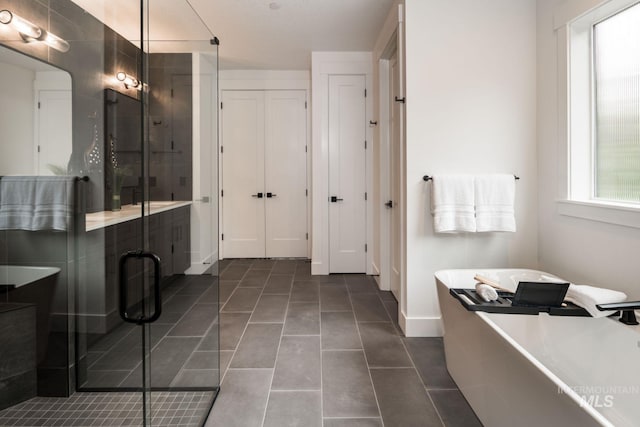 7755 W Flathead Lake St, Eagle, ID 83616 - full bath with a freestanding bath, a shower stall, tile patterned flooring, baseboards, and a closet