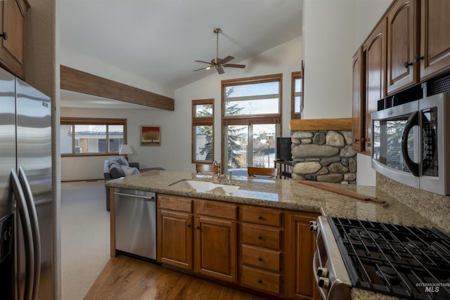 732 Morning Star Rd, Sun Valley, ID 83353 - kitchen with light stone countertops, a peninsula, a sink, stainless steel appliances, and vaulted ceiling