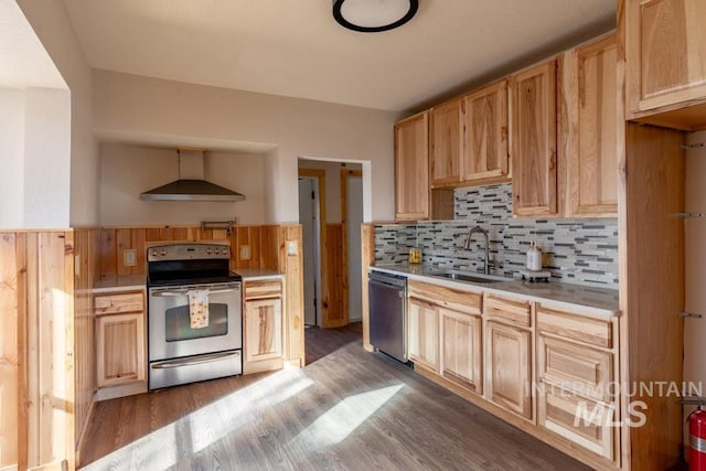 kitchen with stainless steel appliances, light countertops, light brown cabinetry, a sink, and wall chimney range hood