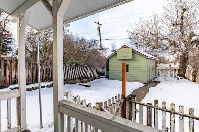 snowy yard featuring an outdoor structure and a fenced backyard