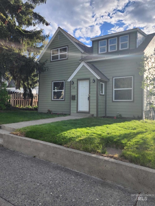 view of front of property featuring a front lawn and fence