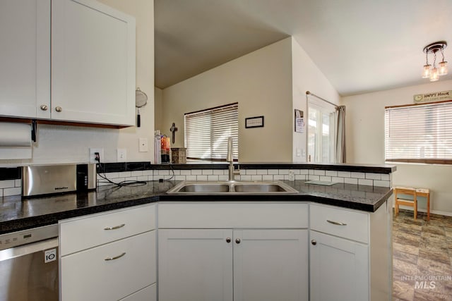 kitchen with stainless steel dishwasher, sink, kitchen peninsula, and white cabinets