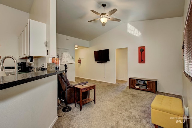 kitchen featuring white cabinetry, light carpet, lofted ceiling, and ceiling fan