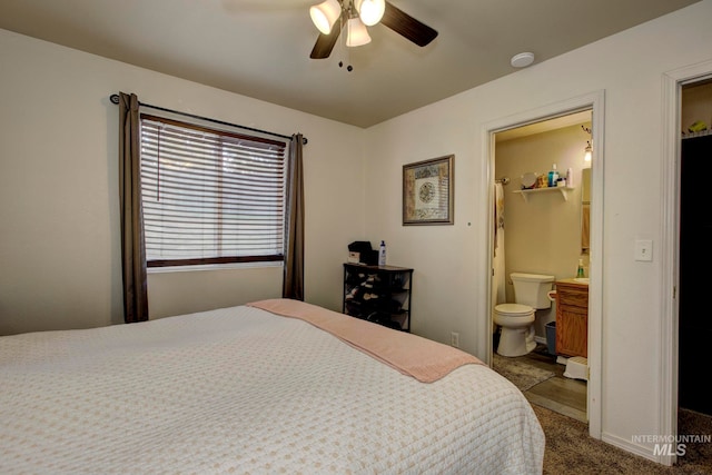 carpeted bedroom featuring connected bathroom, a walk in closet, a closet, and ceiling fan