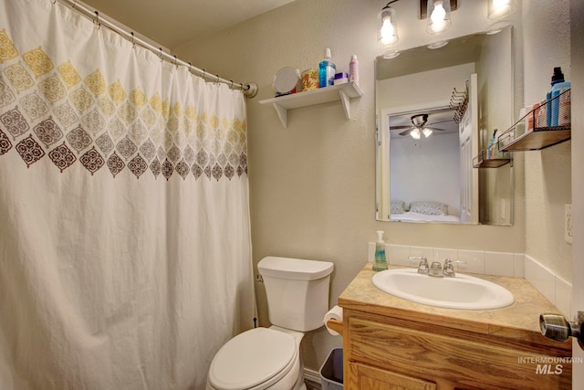 bathroom with vanity, a shower with curtain, toilet, and ceiling fan