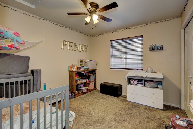 carpeted bedroom featuring a closet, ceiling fan, and a crib