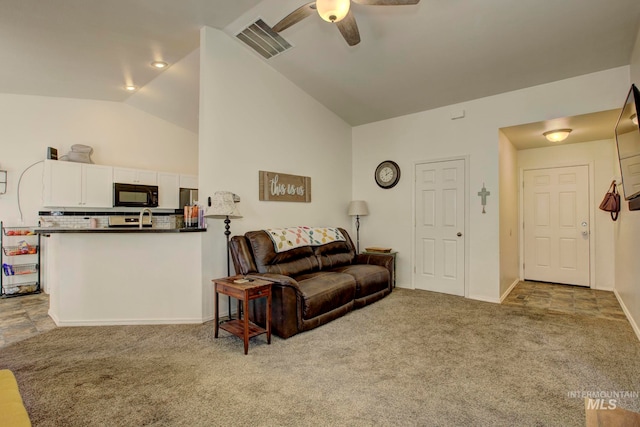 carpeted living room with ceiling fan, sink, and vaulted ceiling