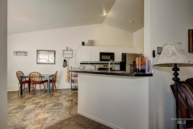 kitchen with white cabinetry, decorative backsplash, lofted ceiling, and kitchen peninsula