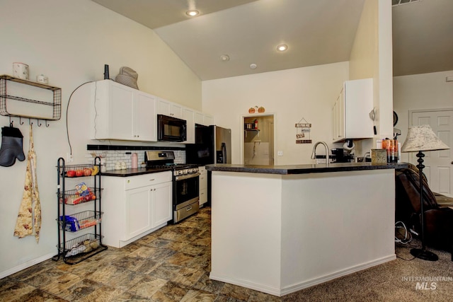 kitchen with kitchen peninsula, white cabinetry, lofted ceiling, dark carpet, and stainless steel gas range oven