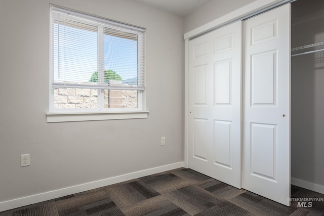 3438 5th St Unit D, Lewiston, ID 83501 - unfurnished bedroom with dark colored carpet, a closet, and baseboards