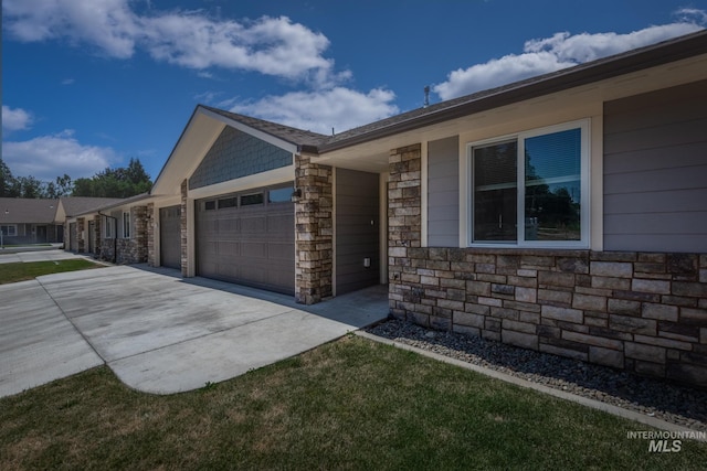 3438 5th St Unit D, Lewiston, ID 83501 - view of side of property with a garage, stone siding, and concrete driveway