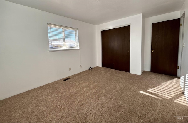 unfurnished bedroom with carpet and a closet