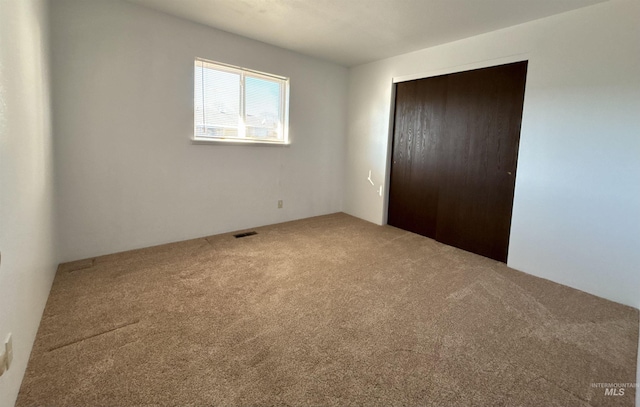 unfurnished bedroom featuring a closet and carpet flooring