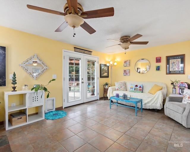 living area with french doors, a textured ceiling, ceiling fan, and tile patterned flooring