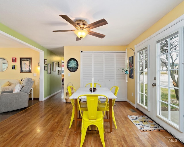 dining area with baseboards, wood finished floors, and a ceiling fan