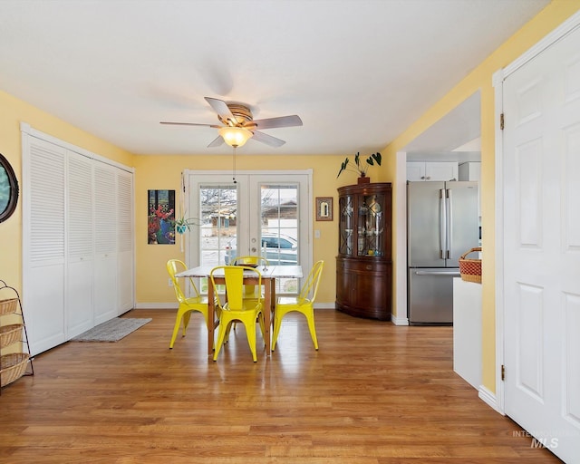 dining room featuring a ceiling fan, light wood-type flooring, and baseboards