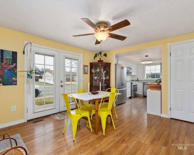 dining space with visible vents, light wood-style flooring, baseboards, and ceiling fan