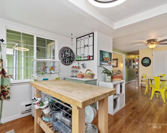 dining space with baseboards, a textured ceiling, wood finished floors, and a ceiling fan