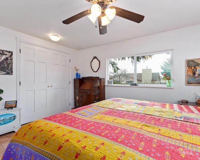 bedroom with a closet, tile patterned flooring, and a ceiling fan