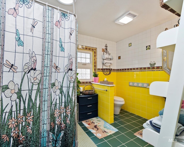 full bath featuring a shower with shower curtain, toilet, tile walls, and tile patterned flooring