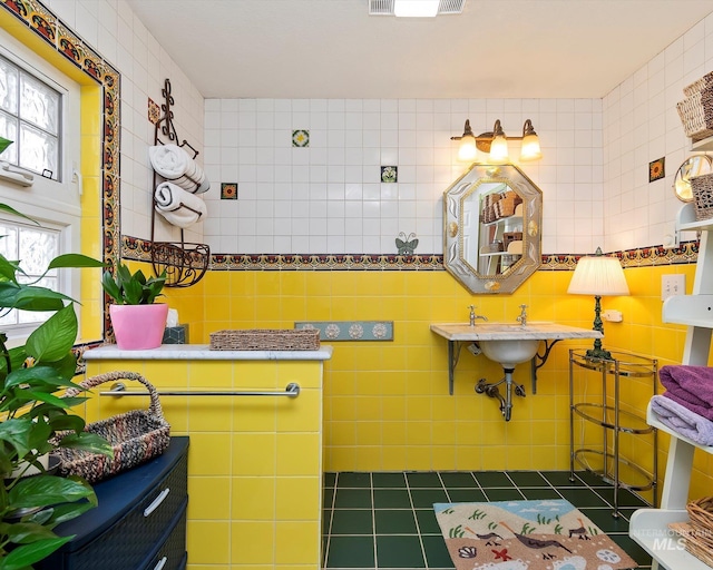 bathroom with tile patterned flooring, visible vents, and tile walls