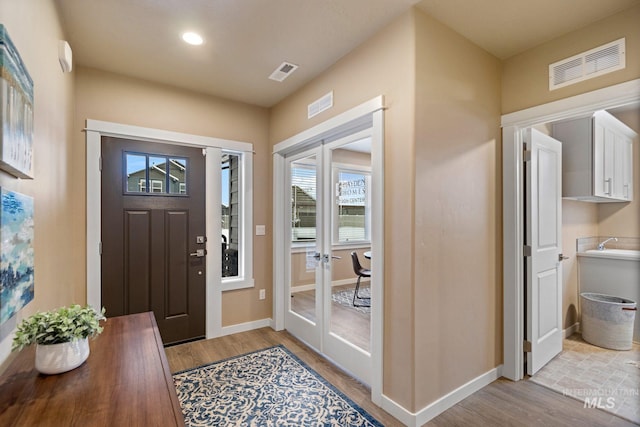 entrance foyer with french doors and light wood-type flooring