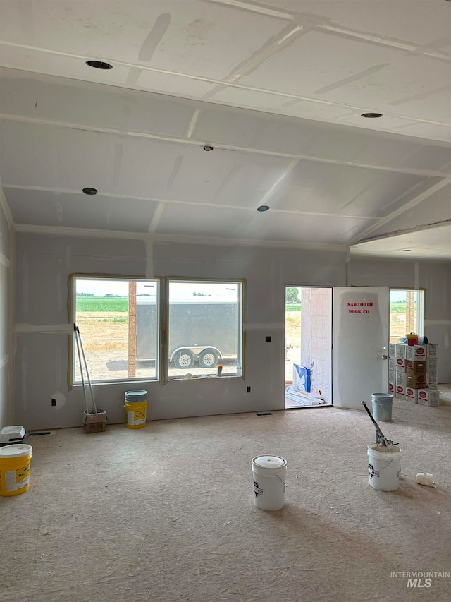 unfurnished living room featuring vaulted ceiling