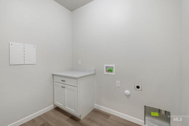 washroom with hookup for an electric dryer, light hardwood / wood-style floors, cabinets, and washer hookup