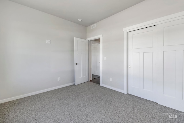 unfurnished bedroom featuring carpet floors and a closet