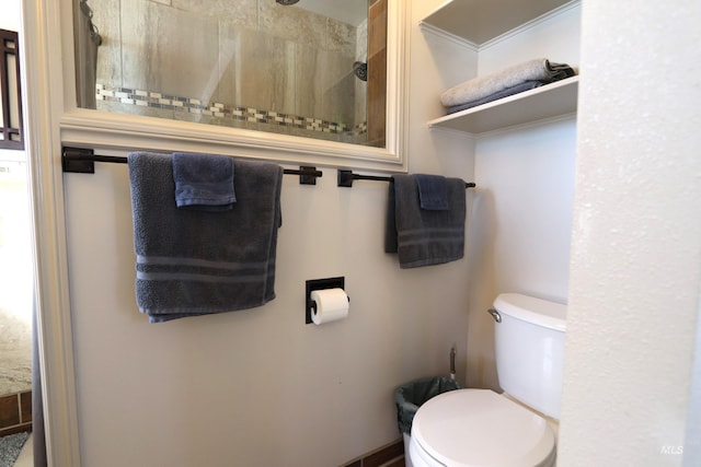 full bathroom featuring a tile shower and toilet