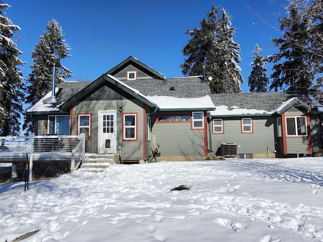 snow covered house with central AC unit