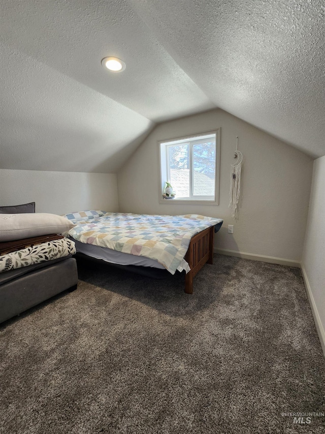 bedroom with dark colored carpet, lofted ceiling, baseboards, and a textured ceiling